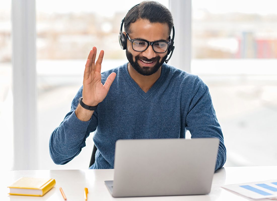 Contact - Friendly Business Man Speaking to a Client on a Laptop at an Office